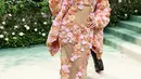 Kelsea Ballerini menampilkan couture Michael Kors dengan hiasan bunga berwarna oranye, merah muda, dan kuning di sepanjang lengan dan bawah gaunnya, yang juga memiliki panel tipis yang disematkan untuk memberi kesan seksi. [Foto: Instagram/stylewithtiffanyblair]