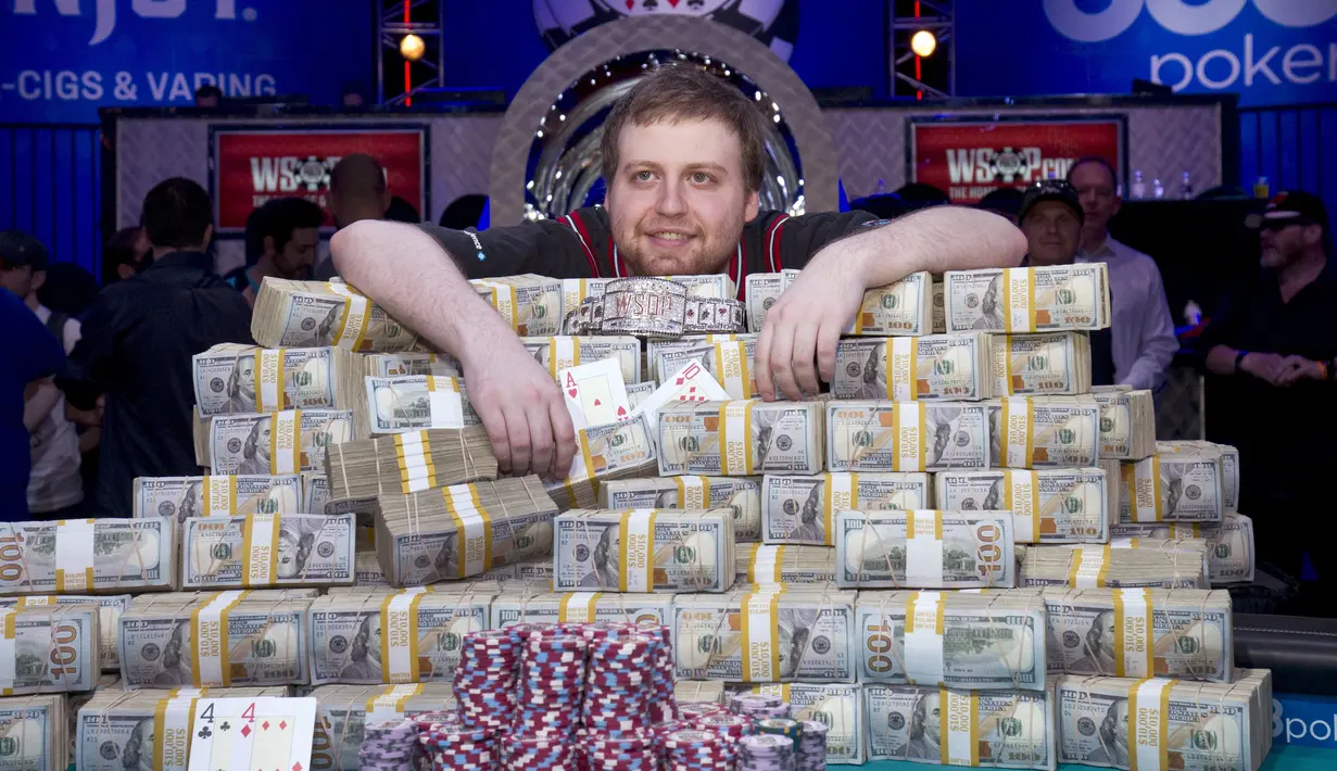 Joe McKeehen berpose diatas tumpukan uang yang ia menangkan dalama kejuaraan poker dunia di Las Vegas, Amerika Serikat, (10/11/2015). McKeehen memenangkan uang 107 Miliar rupiah dan gelang tanda kemenangan dalam kejuaraan ini. (REUTERS/Steve Marcus)