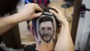 Seorang penata rambut, Mario Hvala mencukur rambut bagian belakang pelanggannya dengan gambar wajah pemain Argentina, Lionel Messi di Serbia, 10 Juni 2018. Hvala memberikan biaya gratis dalam rangka merayakan Piala Dunia 2018. (AFP/VLADIMIR ZIVOJINOVIC)