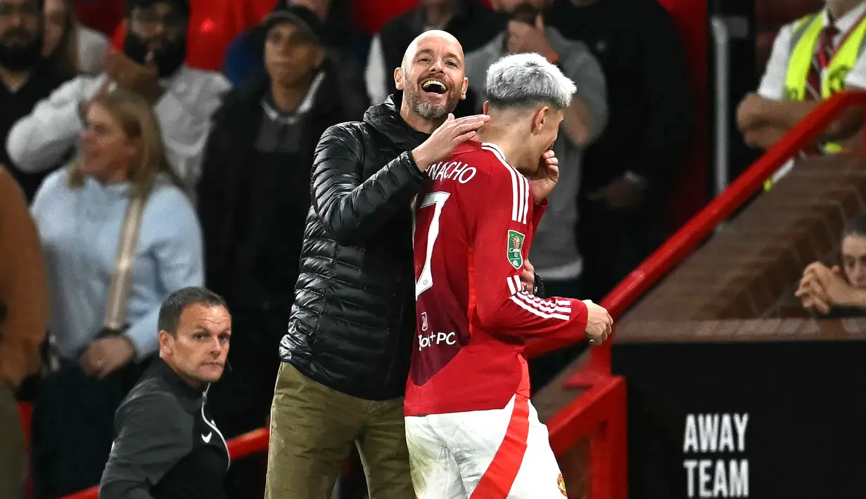 Pelatih Manchester United, Erik ten Hag bercanda dengan pemainnya, Alejandro Garnacho saat pergantian pemain pada laga Carabao Cup 2024/2025 melawan Barnsley di Old Trafford, Manchester, Inggris, Rabu (18/09/2024) WIB. (AFP/Paul Ellis)