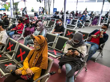 Calon penumpang mengantre untuk menjalani swab antigen di Stasiun Senen, Jakarta, Senin (21/12/2020). Penumpang kereta api jarak jauh menunjukkan surat bebas Covid-19 dengan melakukan tes PCR atau tes rapid antibodi yang masih berlaku 14 hari sejak diterbitkan. (Liputan6.com/Faizal Fanani)