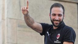 Pemain baru AC Milan, Gonzalo Higuain menyapa suporter dari balkon di alun-alun pusat Milan Piazza Duomo (3/8). AC Milan telah mendatangkan lima pemain baru pada bursa transfer musim panas tahun ini. (AFP Photo/Stringer)