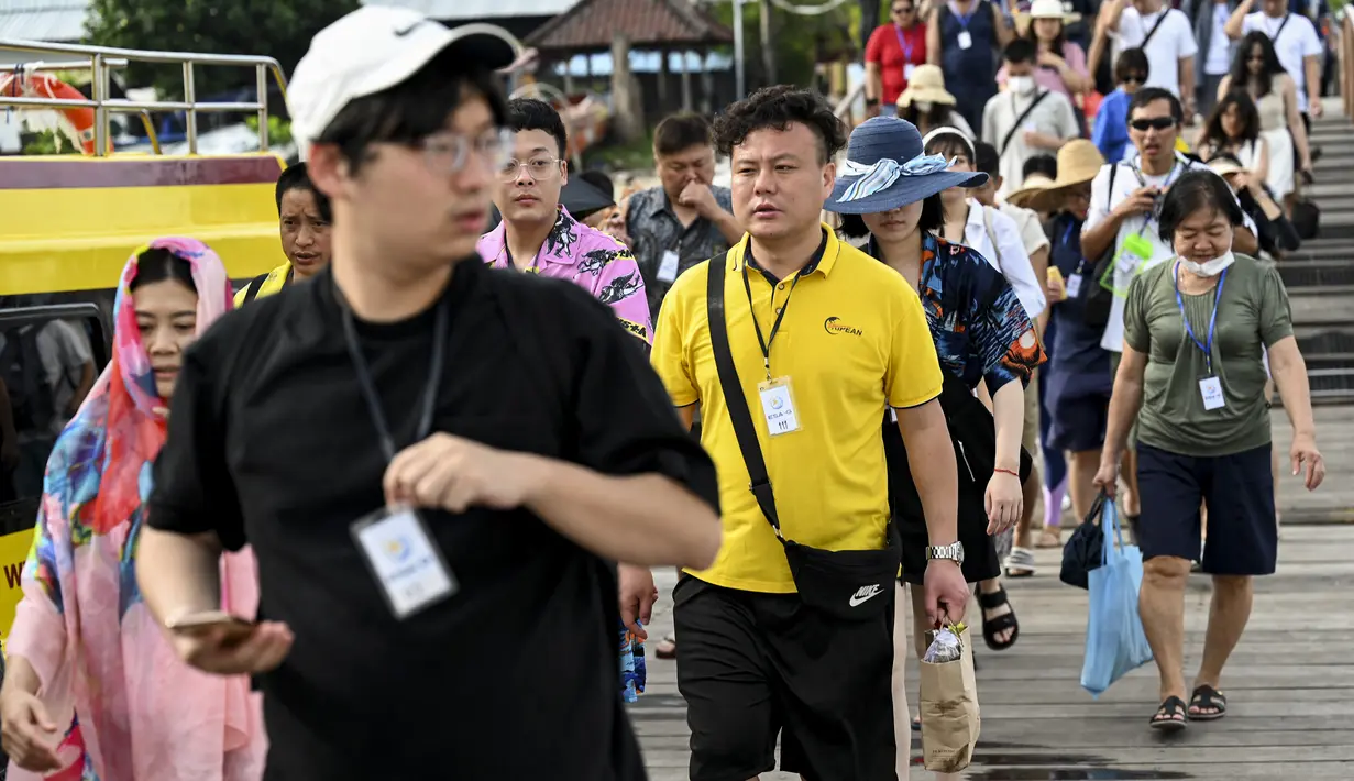 <p>Turis China berjalan untuk menaiki kapal cepat untuk perjalanan dari Pulau Serangan ke Pulau Lombok di Denpasar, Bali, Rabu (25/1/2023). Pelancong dari China diketahui suka berwisata tirta atau water sport. Turis China juga suka membeli buah-buahan dan minuman. (AFP/Sonny Tumbelaka)</p>