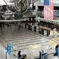 Orang-orang berjalan melalui terminal keberangkatan internasional yang sepi di Bandara John F. Kennedy (JFK), New York City, Sabtu (8/3/2020). Maskapai penerbangan terpukul wabah virus corona (COVID-19) setelah pelancong bisnis maupun rekreasi membatalkan rencana. (Spencer Platt/Getty Images/AFP)