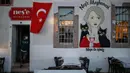 Seorang pekerja toko menunggu pelanggan di kota Ayvalik di Laut Aegea, Turki, Rabu (9/9/2020). Turki telah mewajibkan penggunaan masker di semua lokasi selain di rumah, menyusul lonjakan jumlah infeksi COVID-19. (AP Photo/Emrah Gurel)