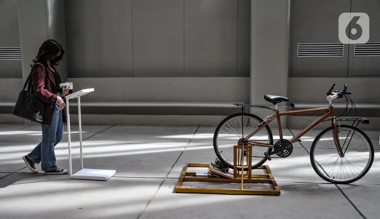 Pengunjung mengamati salah satu karya yang dipamerkan Jakarta Biennale 2021 di Museum Nasional, Jakarta, Selasa (23/11/2021). Ajang seni rupa dua tahunan Jakarta Biennale kembali digelar setelah sempat tertunda akibat pandemi Covid-19. (merdeka.com/Iqbal S. Nugroho)