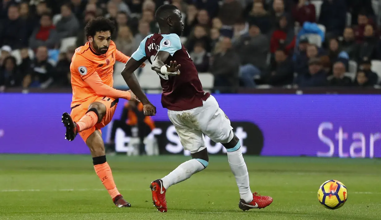 Aksi pemain Liverpool, Mohamed Salah melepaskan tembakan melewati adangan pemain West Ham, Cheikhou Kouyate pada lanjutan Premier League di London Stadium, London, (4/11/2017). Liverpool menang 4-1. (AP/Kirsty Wigglesworth)