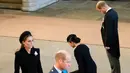 <p>Pangeran William didampingi Kate Middleton dan Pangeran Harry bersama Meghan Markle mengikuti prosesi persemayaman Ratu Elizabeth II di Westminster Hall di London (14/9/2022). Diperkirakan ratusan ribu orang akan datang memberikan penghormatan sebelum dimakamkan pada 19 September 2022. (Photo by Christopher Furlong / POOL / AFP)</p>