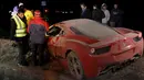 Sejumlah warga melihat kondisi mobil ferrari milik Arturo Vidal yang rusak parah usai mengalami kecelakaan di Kota Buin, Chile, Selasa (16/6/2015). Arturo Vidal mengalami luka ringan dan langsung dibawa ke rumah sakit. (REUTERS/Felipe Fredes)