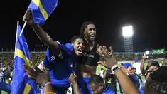 Pemain dan suporter Timnas Curacao merayakan hasil imbang melawan Jamaika pada Grup B Kualifikasi Piala Dunia 2026 zona CONCACAF di Independence Park Stadium, Jamaika pada 18 November 2025. Timnas Curacao memastikan tempat di Piala Dunia 2026. (Ricardo MAKYN/AFP)