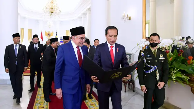 Presiden Jokowi memberikan kenang-kenangan berupa album foto kepada PM Malaysia Anwar Ibrahim. (Foto: Sekretariat Presiden)