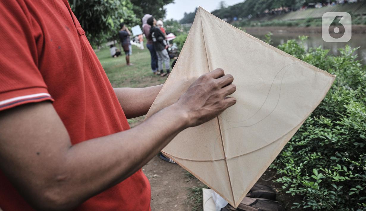 Warga bermain layang-layang di pinggir Kanal Banjir Timur (KBT), Duren Sawit, Jakarta, Senin (19/4/2021). KBT menjadi lokasi favorit warga untuk mengisi waktu menunggu buka puasa atau ngabuburit, salah satunya dengan bermain layang-layang bersama keluarga. (merdeka.com/Iqbal S Nugroho)