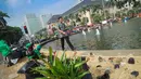 Petugas dinas pertamanan membersihkan Taman Silang Monas yang rusak akibat injakan massa Prabowo, Jakarta, Jumat (22/8/14). (Liputan6.com/Faizal Fanani)