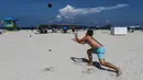 Pengunjung bermain bola di Miami Beach di Florida, Rabu (10/6/2020). Pantai Miami dibuka hari ini untuk pertama kalinya setelah hampir tiga bulan ditutup guna menekan jumlah penyebaran corona Covid-19. (CHANDAN KHANNA / AFP)
