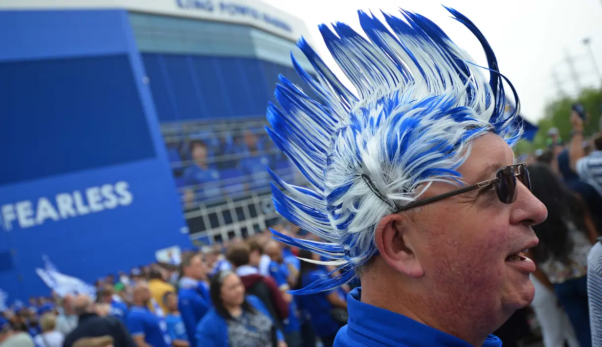 Seorang fans Leicester City dengan rambut berwarna klub kesayangannya memeriahkan perayaan  titel juara Liga Inggris 2015-2016 di Areal Stadion King Power (7/5/2016). (AFP/Glyn Kirk)