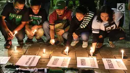 Gabungan suporter klub sepak bola menyalakan lilin dalam aksi solidaritas terkait tragedi teror bom di Surabaya dan Sidoarjo di Taman Suropati, Jakarta, Senin (14/5). (Liputan6.com/Immanuel Antonius)