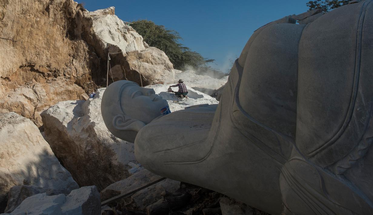 Pekerja melakukan aktivitas dekat patung Buddha di desa Sagyin, Madaya, Myanmar pada 22 Desember 2018. Desa Zagyin atau biasa disebut Marble ini merupakan tempat terbesar di dunia dalam memproduksi patung Buddha dalam segala ukuran. (YE AUNG THU / AFP)