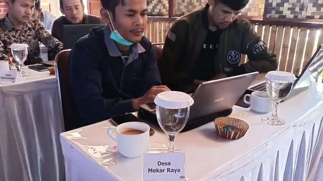 Operator Desa Mekar Jaya, Kecamatan Tarogong Kaler, Kabupaten Garut, Jawa Barat fokus mendengarkan arahan bimbingan pelatihan operator Sistem Informasi Desa (SID) SMK Wikrama Garut. (Liputan6.com/Jayadi Supriadin)