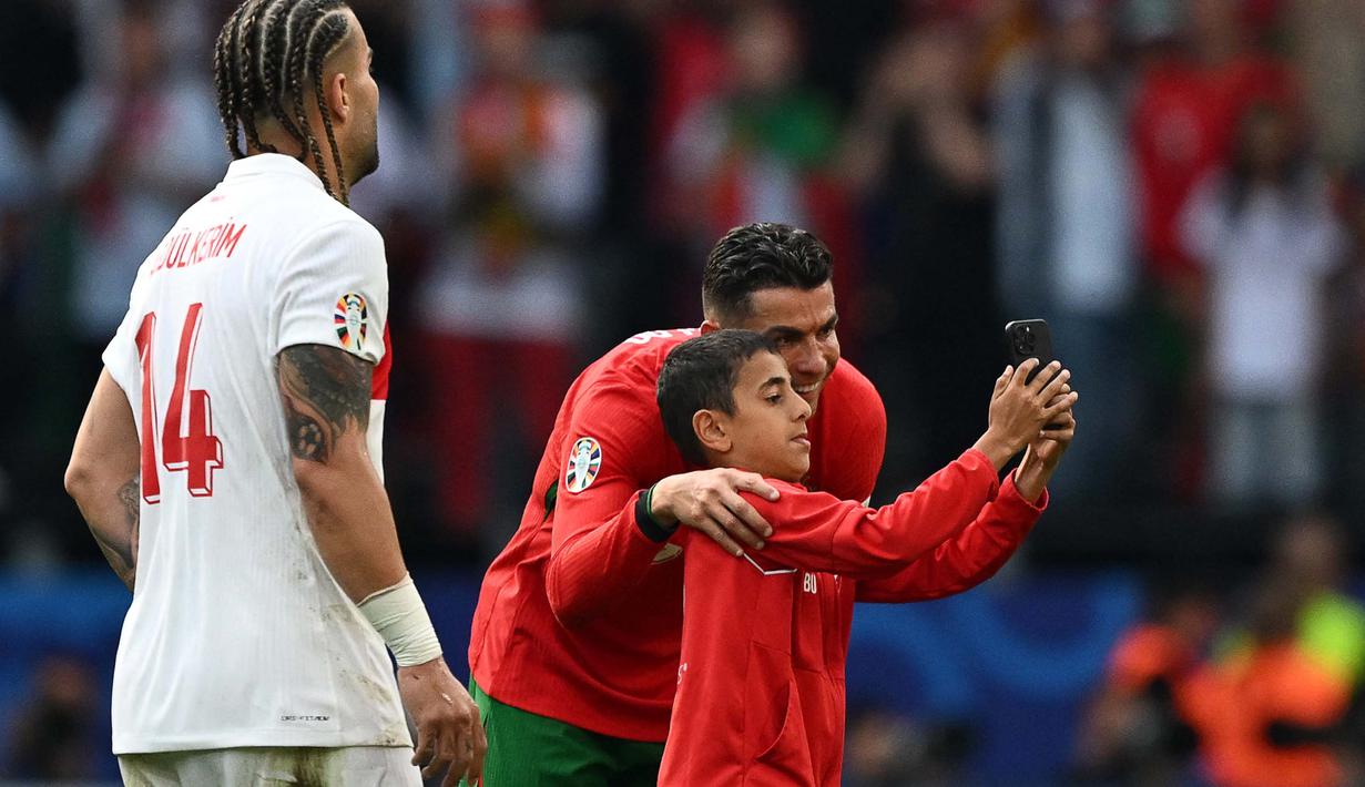 Tercatat, pertandingan antara Turki melawan Portugal harus dihentikan sebanyak empat kali karena tindakan para suporter tersebut. (PATRICIA DE MELO MOREIRA/AFP)