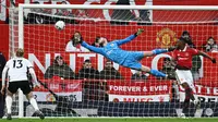 Penjaga gawang Manchester United, David de Gea (tengah), berhasil menghalau tendangan dari pemain Fulham dalam pertandingan yang berlangsung di Old Trafford, Minggu (19/3/2023). (AFP/Paul Ellis)