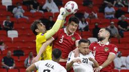 Kiper Timnas Irak, Jalal Hassan (kiri) berusaha menghalau bola dari ancaman bek Timnas Indonesia, Elkan Baggott (tengah) pada laga pertama Grup D Piala Asia 2023 Qatar di Ahmad bin Ali Stadium, Al-Rayyan, Doha, Senin (15/1/2024). (AFP/Karim Jaafar)