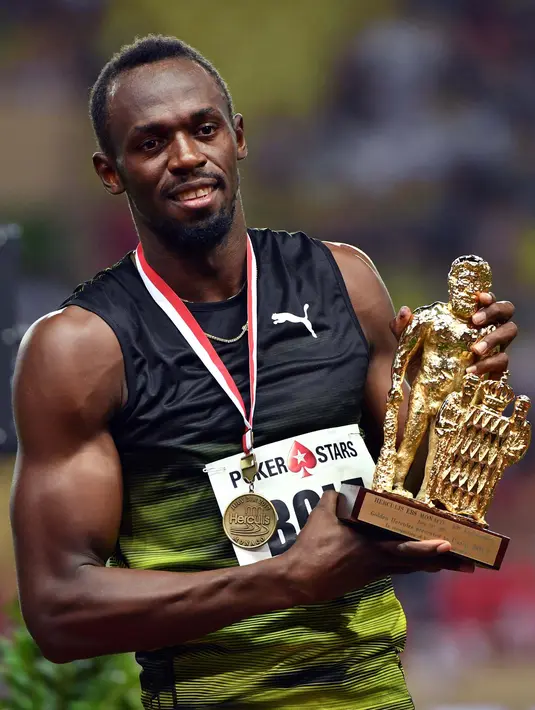 Usain Bolt berpose dengan medali yang diraihnya usai menjuarai kejuaraan atletik lari 100m Diamond League di Stadium Louis II, Monaco, (21/7). (AFP Photo/Yann Coatsaliou)