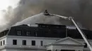 Petugas pemadam kebakaran memadamkan api yang membakar Gedung Parlemen di Cape Town, Afrika Selatan, 3 Januari 2022. Setelah sempat berhasil dipadamkan, api kembali mengamuk dan membakar Gedung Parlemen Afrika Selatan. (AP Photo/Nardus Engelbrecht)