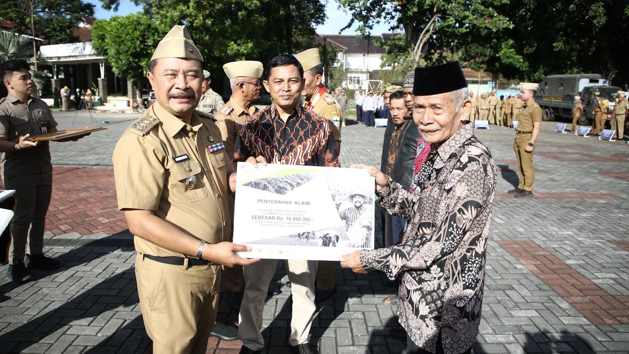 Penjabat Bupati Garut, Barnas Adjidin, secara simbolis menyerahkan klaim asuransi usaha tani padi (AUTP) perwakilan empat kelompok tani, terdampak gagal panen di Garut saat ini. (Liputan6.com/Jayadi Supriadin)