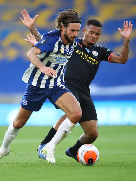 Gelandang Brighton and Hove Albion, Davy Propper (kiri) berebut bola dengan striker Manchester City, Gabriel Jesus pada Pekan ke-35 Liga Inggris di stadion The American Express, Minggu (12/7/2020). Manchester City berpesta gol di markas Brighton. (Julian Finney / POOL / AFP)