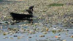 Warga menggunakan perahu untuk memilah sampah plastik di aliran Sungai Citarum, Bandung, Jawa Barat, Rabu (26/6/2019). Berbagai upaya dilakukan pemerintah untuk membersihkan sungai yang menyandang predikat salah satu tempat paling tercemar di dunia ini. (Timur Matahari/AFP)