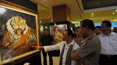 Kapolri Jenderal Badrodin Haiti menyimak penjelasan Pelukis Cak Kandar di Hotel Sultan Jakarta, Senin (21/3/2016). Kehadiran Kapolri Badrodin Haiti untuk meresmikan Pameran Lukisan Dua Tanda. (Liputan6.com/Faisal R Syam)