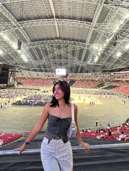 Shenina Cinnamon berkesempatan nonton konser Harry Styles, ia pun tampil mengenakan atasan tube dipadukan celana panjang denim putih bermotif. [@shenacinnamon]