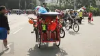 Seorang Warga Negara Asing mengendarai becak saat Hari Bebas Kendaraan di Kawasan Bundaran HI, Minggu (7/5). Aksinya ini sempat menarik perhatian warga. (Liputan6.com/Helmi Fithriansyah)