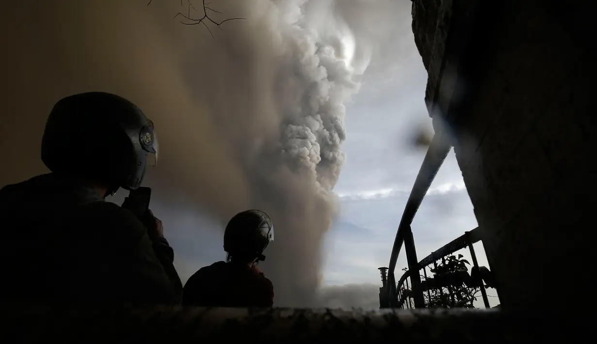 Sejumlah orang menyaksikan Gunung Api Taal erupsi di Tagaytay, Provinsi Cavite, Filipina, Minggu (12/1/2020). Suara bergemuruh terdengar disertai gempa bumi dan kilat di atas puncaknya. (AP Photo/Aaron Favila)