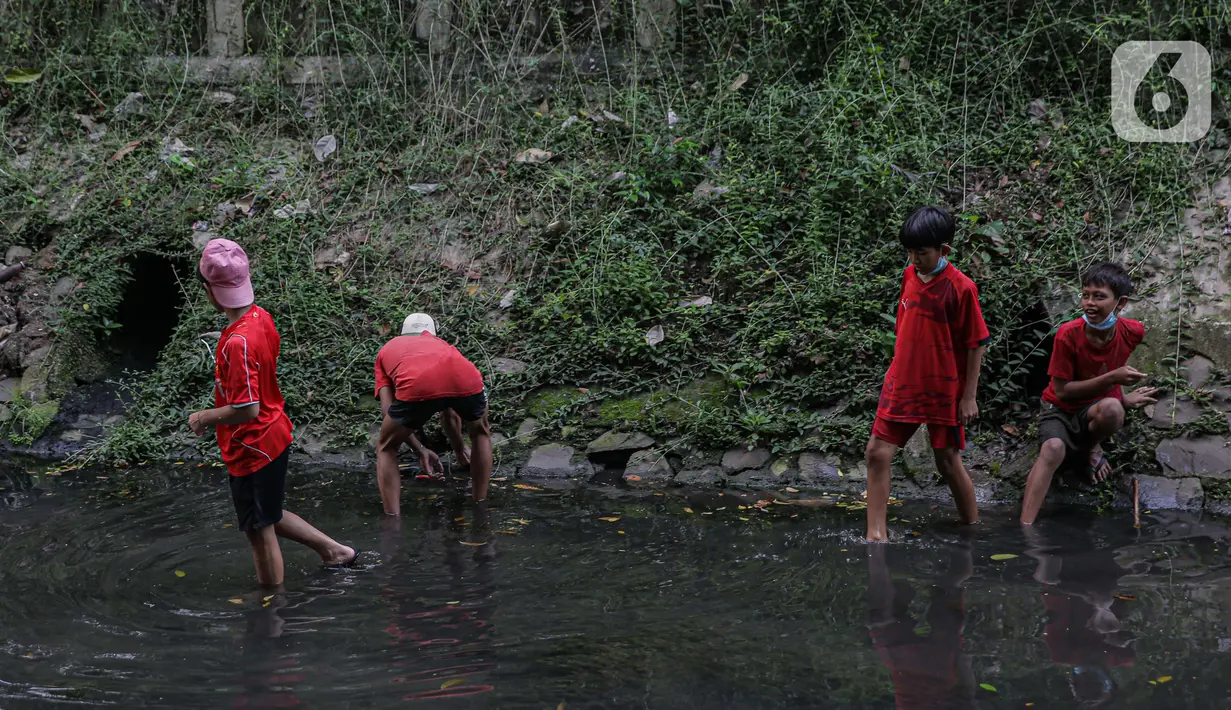 Sejumlah anak-anak mencari belut di anak kali menteng, Jakarta, Selasa (8/6/2021). Ruang bermain anak-anak di Jakarta kian terbatas. Terbatas lahan bermain membuat anak-anak Jakarta bermain ditempat yang tak semestinya demi mencari kesenangan. (Liputan6.com/Faizal Fanani)