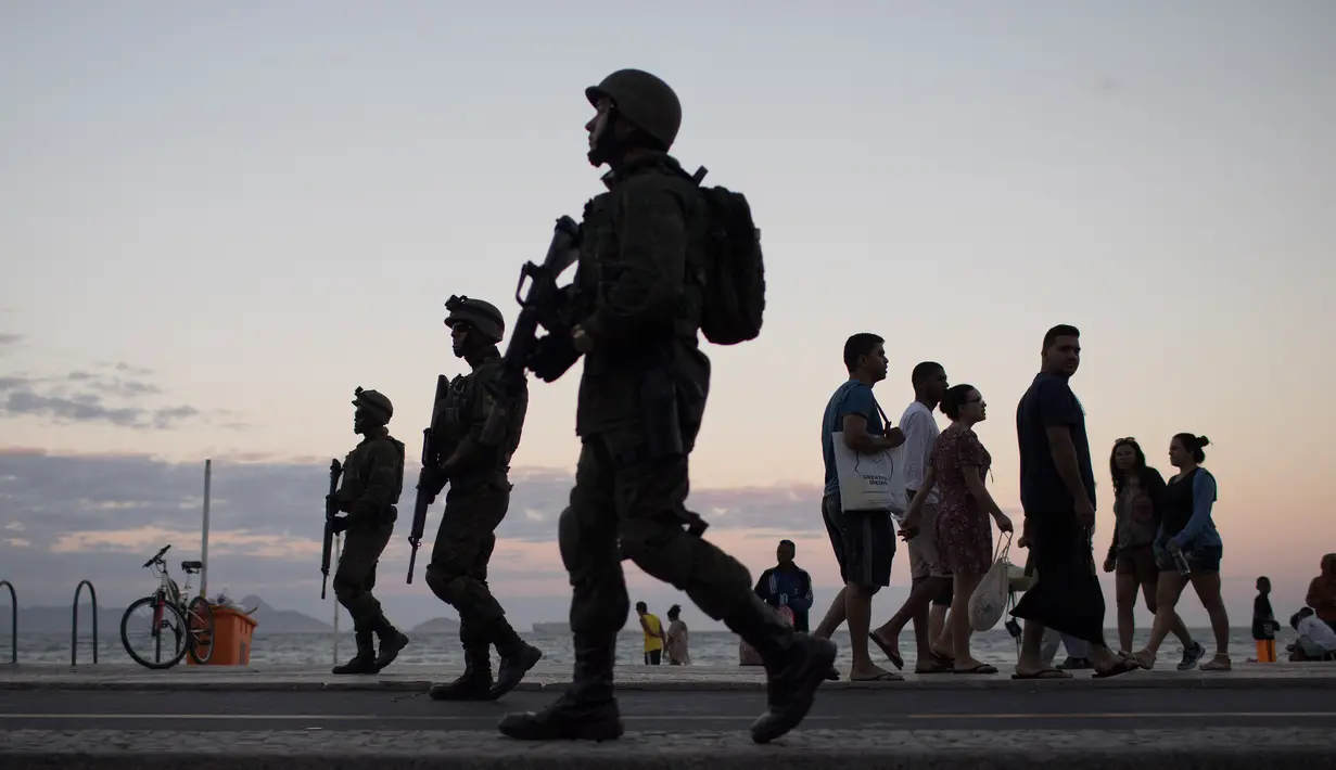 Sejumlah tentara patroli di pantai Copacabana di Rio de Janeiro, Brasil, (30/7). Ribuan tentara mulai berpatroli di Rio de Janeiro di tengah lonjakan kekerasan di kota terbesar kedua di Brasil. (AP Photo / Leo Correa)