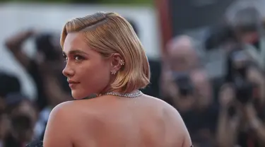 Florence Pugh berpose untuk fotografer setibanya di pemutaran perdana film 'Don't Worry Darling' selama Venice Film Festival 2022 ke-79 di Venesia, Italia (5/9/2022). Pugh tampil memesona dalam gaun sifon hitam yang menampilkan lengan off-shoulder engah raksasa dan ditutupi payet. (Photo by Vianney Le Caer/Invision/AP)