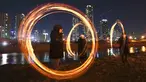 Peserta memutar kaleng arang yang terbakar menjelang perayaan "Jeongwol Daeboreum" (Bulan Purnama) di sebuah taman di Seoul, Korea Selatan (1/3). Permainan ini dipercaya dapat menyuburkan tanah dan menyingkirkannya hama. (AFP Photo/Jung Yeon-je)