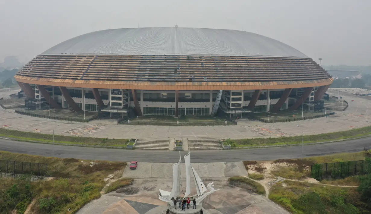 Gambar udara menunjukkan sebuah stadion ketika kabut asap pekat menyelimuti Pekanbaru, Riau, Minggu (15/9/2019). Masyarakat diminta menekan akses asap dengan menutup jendela rumah agar tidak masuk ke dalam. (ADEK BERRY/AFP)