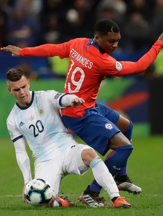 Pemain Argentina, Giovani Lo Celso berebut bola dengan pemain Chile, Junior Fernandes selama bertanding pada perebutan tempat ketiga Copa America 2019 di Arena Corinthians, Brasil (6/7/2019). Argentina sukses  merebut posisi ketiga usai mengalahkan Chile 2-1. (AP Photo/Andre Penner)
