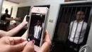 Gambar Neil Bantleman diabadikan oleh salah seorang teman yang datang untuk memberi dukungan kepada Neil yang akan menjalani sidang perdana di Pengadilan Negeri Jakarta Selatan, Selasa (2/12/2014). (Liputan6.com/Faizal Fanani)