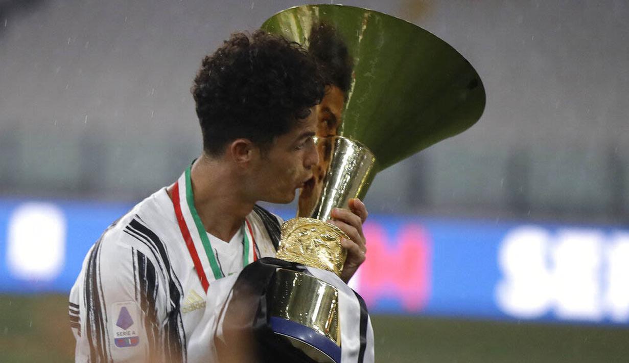 Striker Juventus, Cristiano Ronaldo, mencium trofi juara Serie A musim 2019-20 di Stadion Allianz, Sabtu (1/8/2020). CR7 berhasil membawa Juventus merengkuh gelar Liga Italia kesembilan secara beruntun. (AP Photo/Luca Bruno)