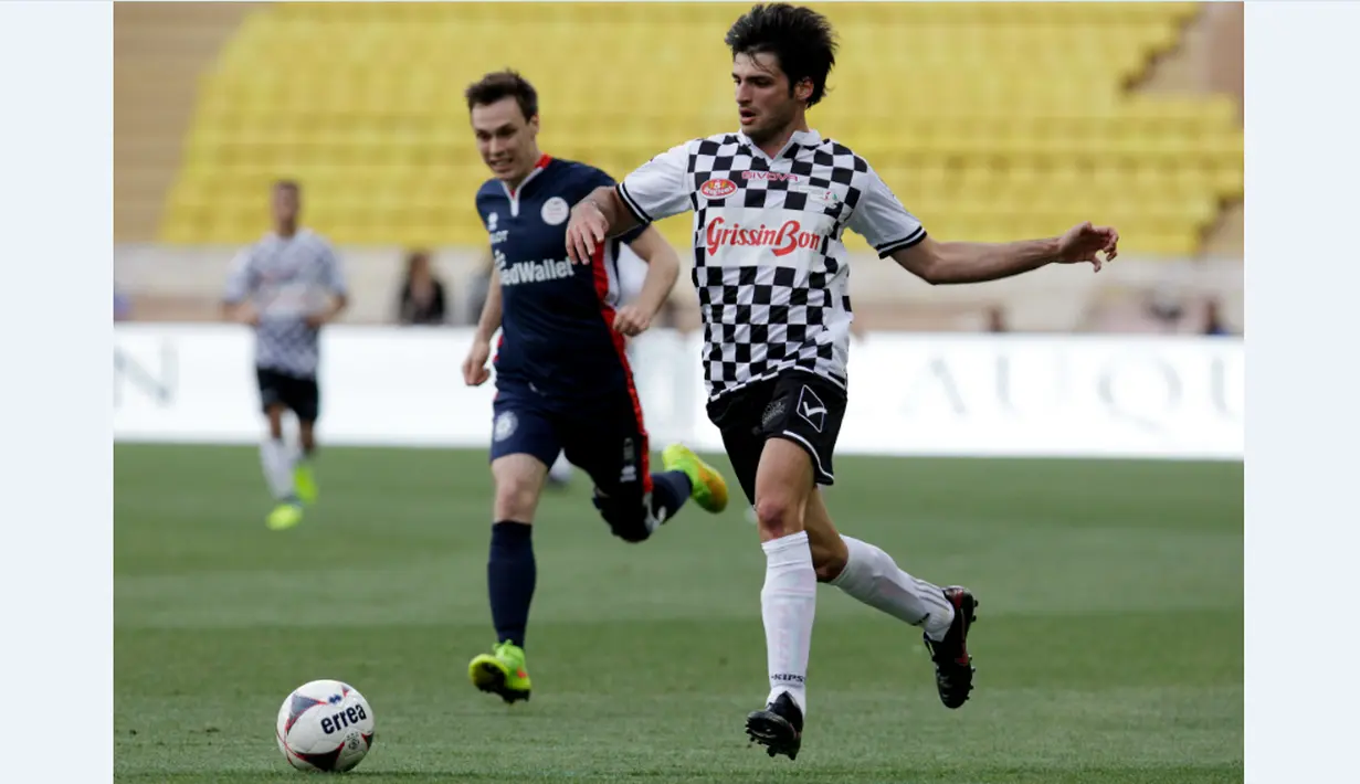 Pebalap Toro Rosso, Carlos Sainz Jr, menggiring bola dalam laga amal melawan tim Pangeran Albert II di Stade Louis II Monako, Selasa (24/5/2016). (AFP/Jean Christophe Magnenet)