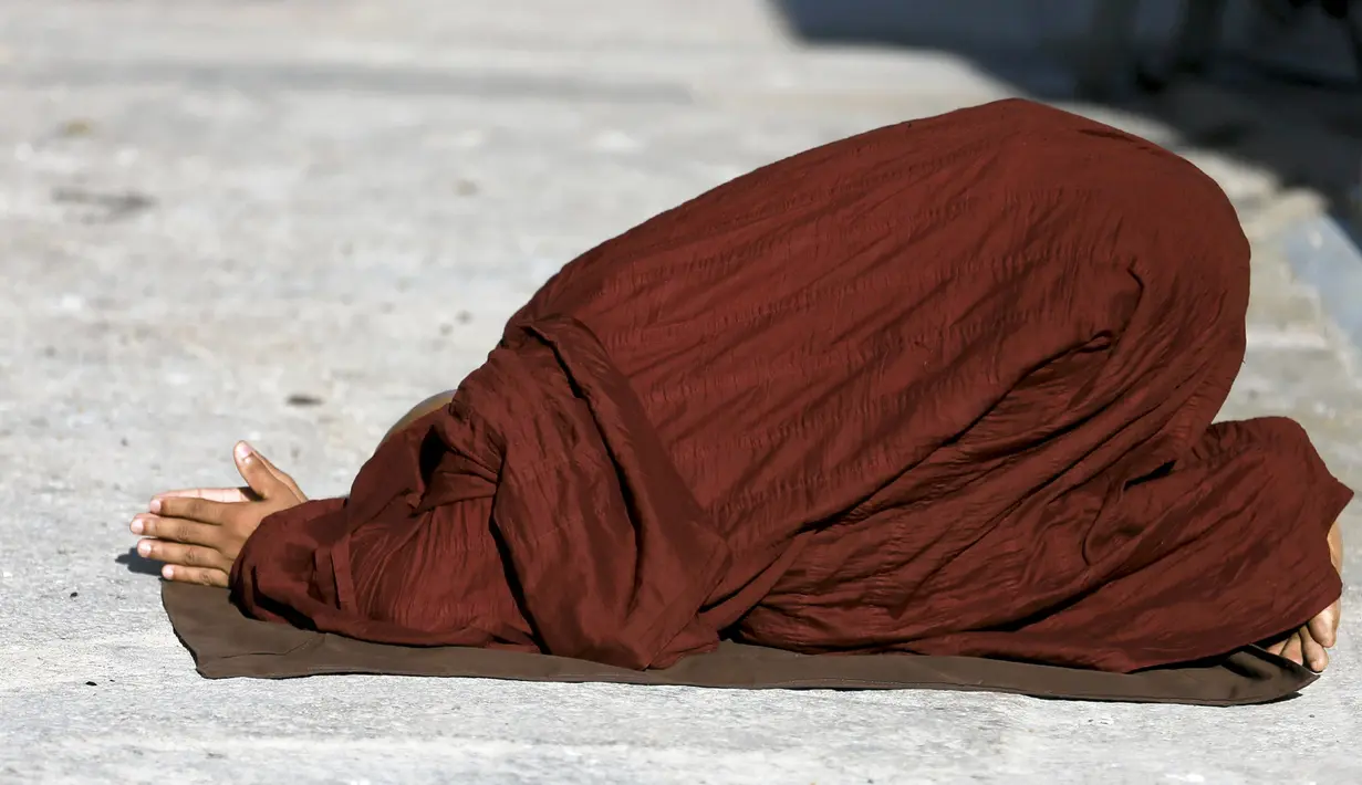 Seorang biksu Buddha berdoa di depan Ruwanweli maha Seya pada hari Poya untuk menandai kunjungan kedua Buddha ke Sri Lanka, di Anuradhapura (21/4). Hari Poya dirayakan menyambut bulan purnama. (REUTERS/Dinuka Liyanawatte)