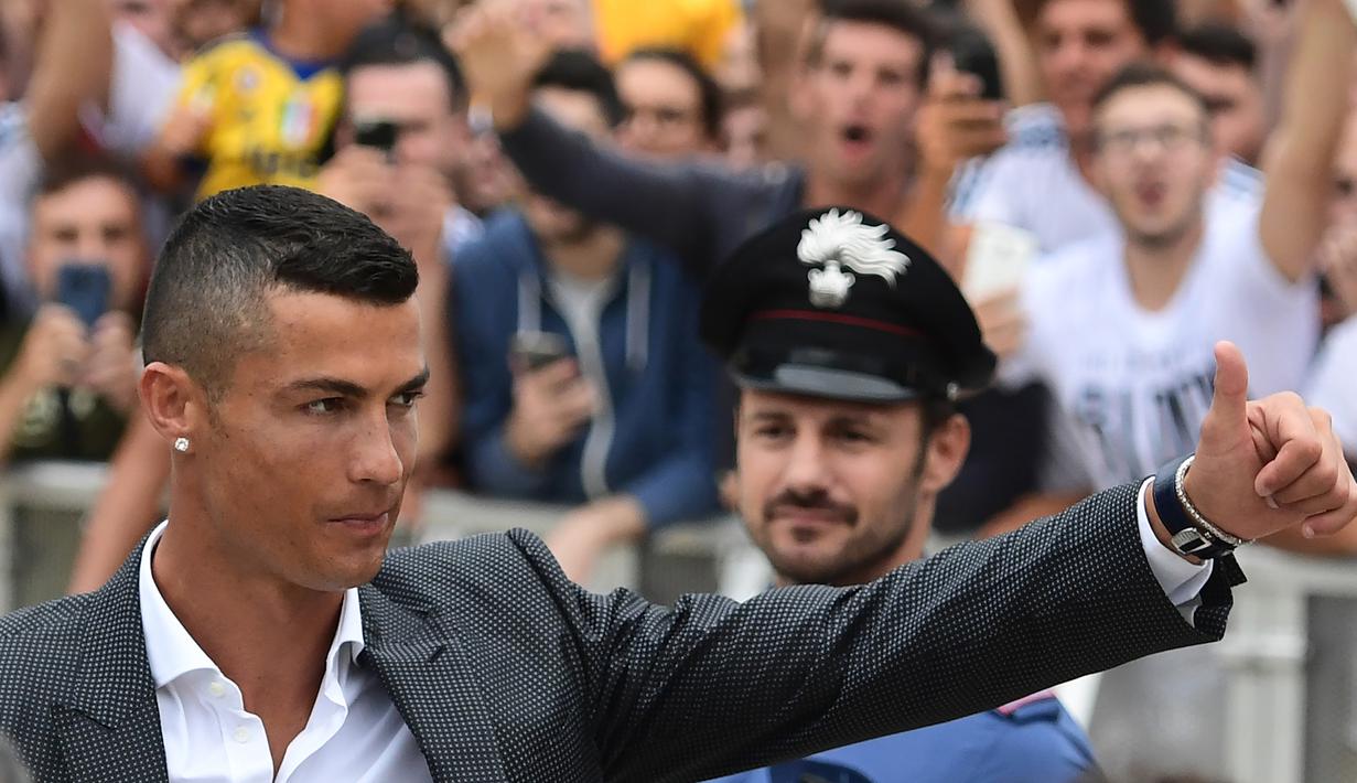 Bintang baru Juventus, Cristiano Ronaldo, menyapa suporter saat tiba untuk menjalani tes kesehatan di area Stadion Allianz, Turin, Senin (17/7/2018). CR 7 hijrah dari Real Madrid ke Juventus. (AFP/Miguel Medina)