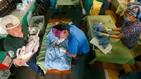 Para dokter hewan lakukan kebiri pada hewan-hewan di Payatas, Manila, Filipina, Selasa (26/9). Kasus rabies di Filipina termasuk yang tertinggi di dunia. HIS perkirakan 200 orang meninggal tiap tahunnya melalui gigitan anjing. (AP Photo/Bullit Marquez)