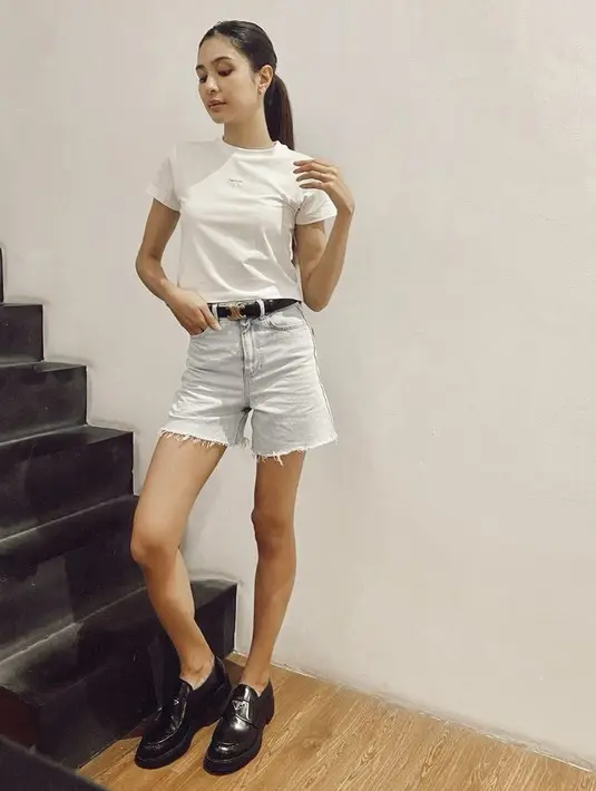 Mikha Tambayong tampil simple mengenakan t shirt putih dipadukan celana pendek denim, gayanya juga terlihat mewah dengan sepatu hitam Pradanya. @mikhatambayong