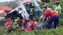 Petugas memberikan pertolongan kepada korban kecelakaan sebuah bus pariwisata di Kota Canico, Pulau Madeira, Portugal, Rabu (17/4). Menurut pejabat perlindungan sipil regional, para turis korban kecelakaan berusia antara 40 hingga 50 tahun. (RUI SILVA / AFP)