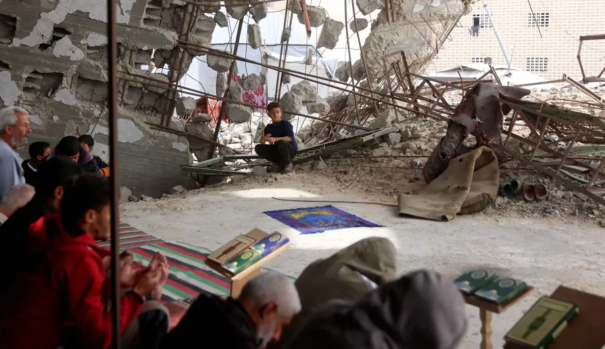 Untuk diketahui, bagi umat Muslim di Gaza, 13 Maret 2026 merupakan Jumat terakhir di bulan suci Ramadan 1447 Hijriah. Tampak dalam foto, warga Palestina berdoa saat salat Jumat terakhir di bulan suci Ramadan 1447 Hijriah, di luar Masjid Al-Talbani, yang dihancurkan oleh militer Israel di Khan Yunis, Jalur Gaza selatan pada Jumat 13 Maret 2026. (Bashar Taleb/AFP)