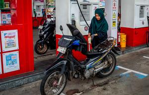 Seorang pengendara sepeda motor mengisi bahan bakar motornya di sebuah Stasiun Pengisian Bahan Bakar Umum (SPBU) yang dioperasikan oleh Pertamina, perusahaan minyak dan gas milik negara Indonesia, di Yogyakarta, pada Sabtu 28 Maret 2026. Konflik antara Iran dengan Amerika Serikat–Israel serta pembatasan di jalur strategis Selat Hormuz berdampak pada lonjakan harga minyak global. (DEVI RAHMAN/AFP)